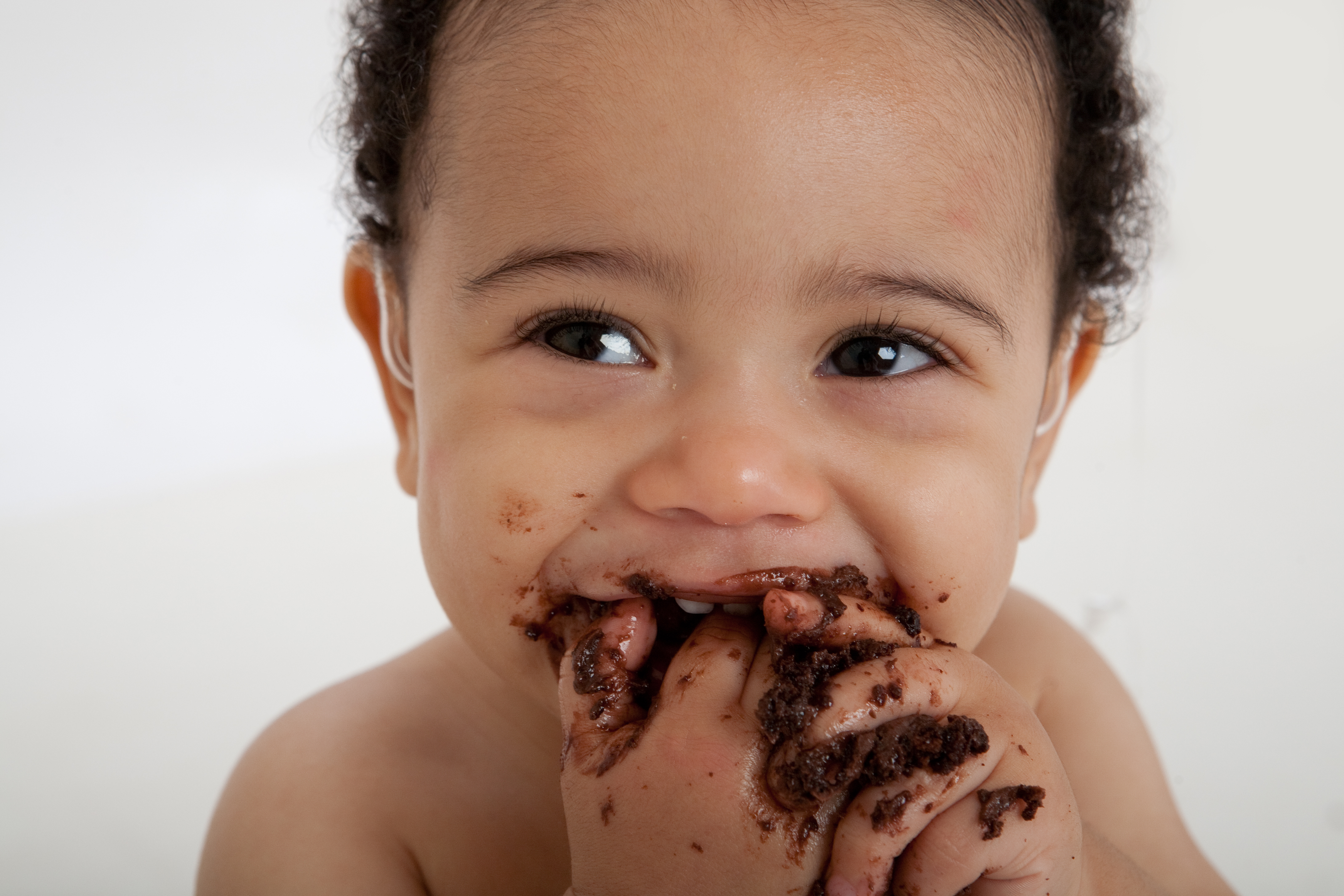 Мальчик с шоколадкой. Ребенок измазался шоколадом. Малыш ест шоколад.