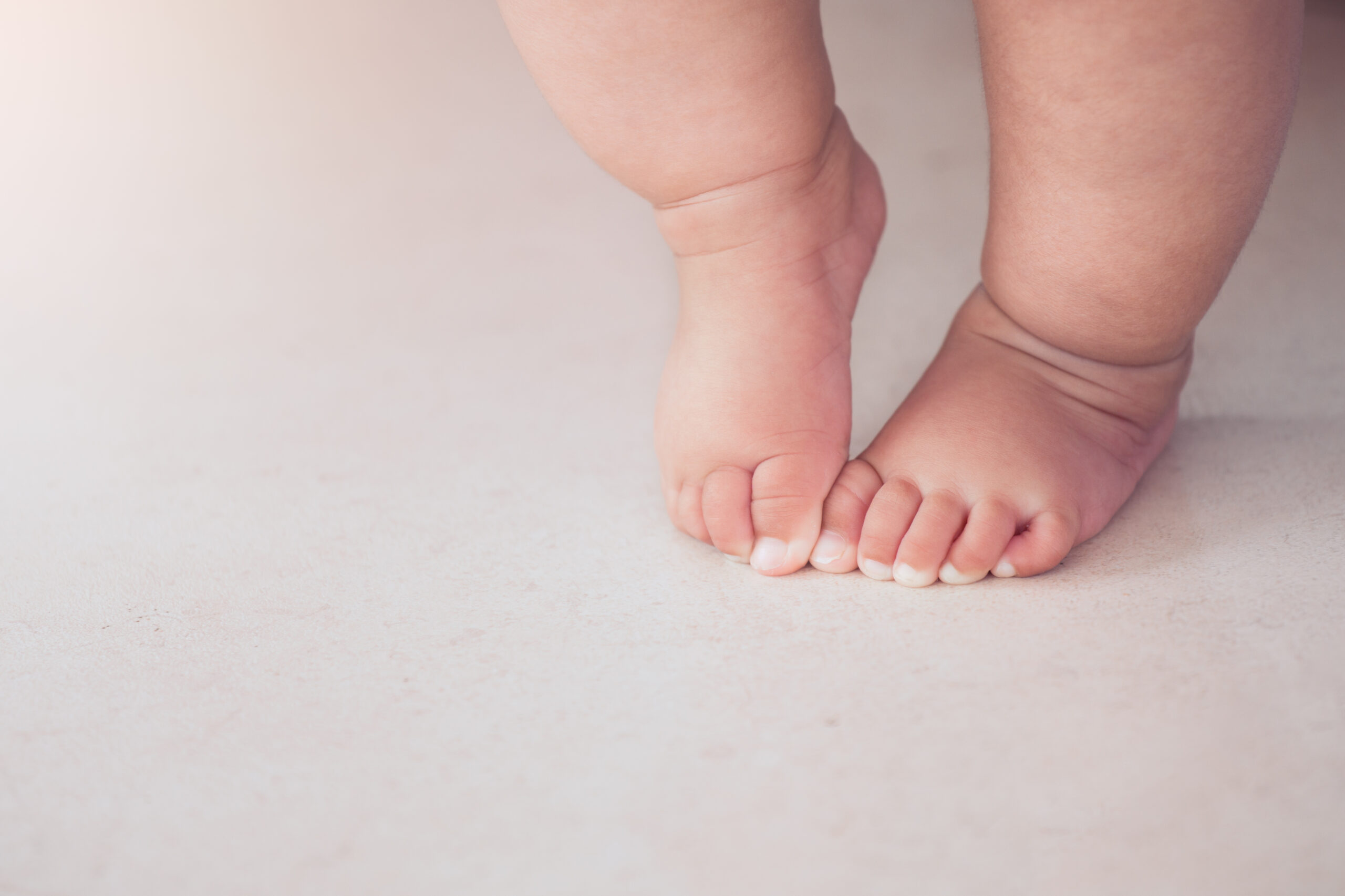 У мамы есть ноги. Стопа малыша. Стопа новорожденного ребенка. Маленькие ножки. Детские ножки на полу.